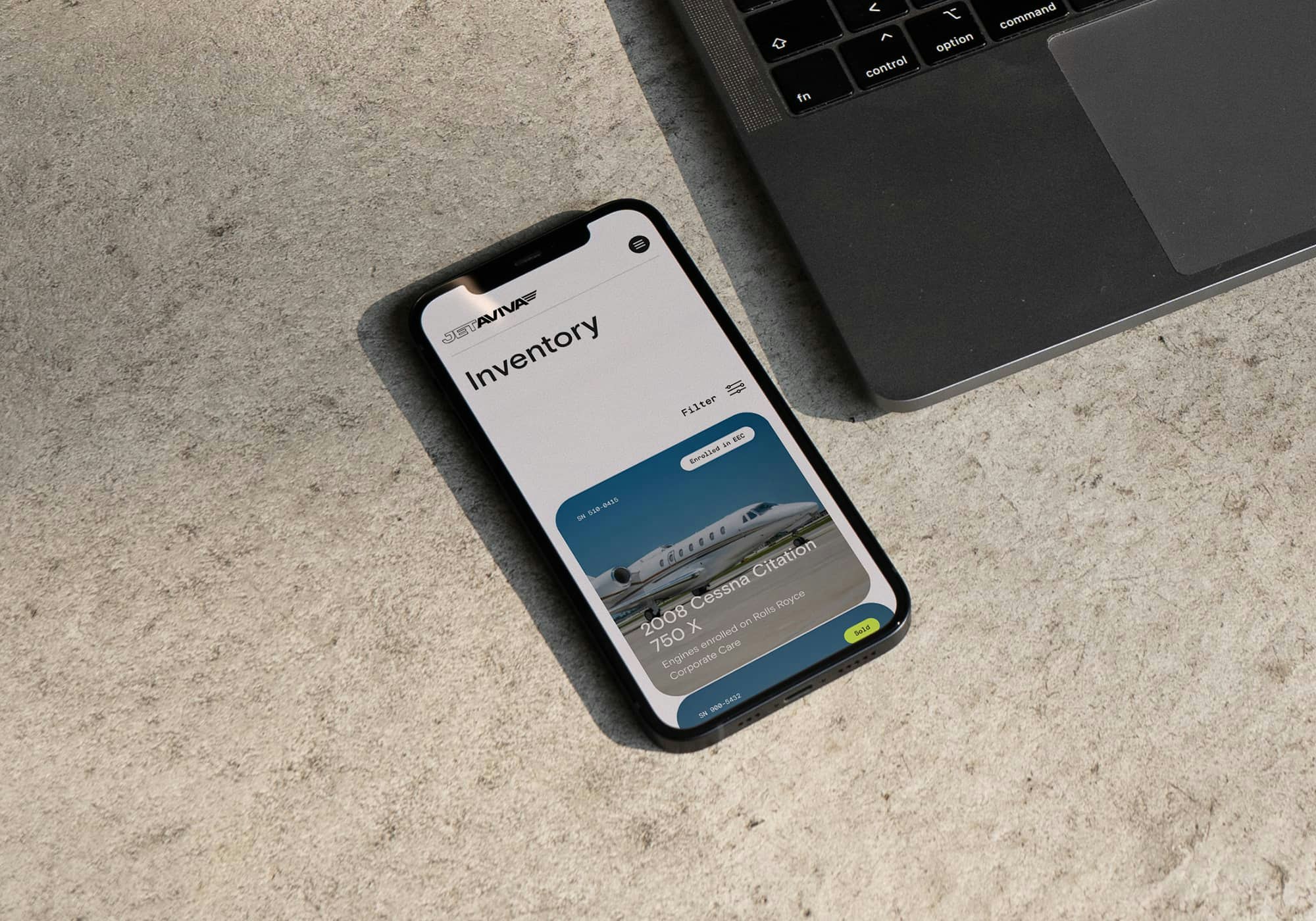 A iPhone placed on a table showcasing the custom web design Inventory page of JetAviva