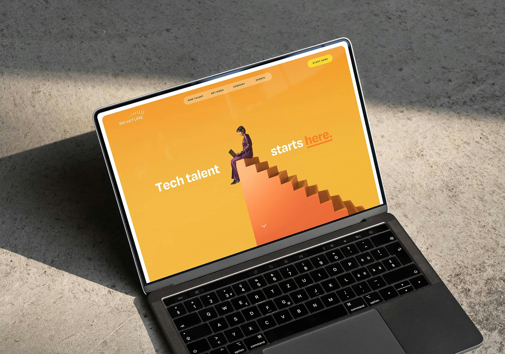 A laptop showcasing the web design of Revature's homepage